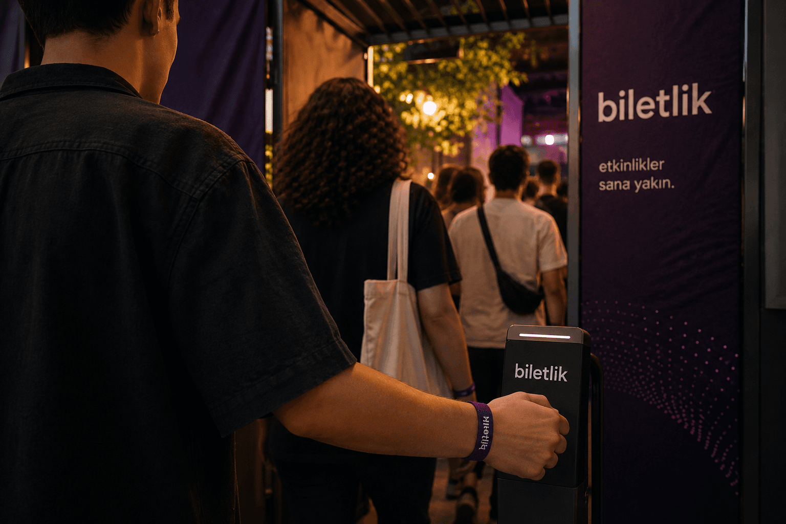 biletlik giriş noktasında bilekliğiyle etkinliğe giren katılımcı